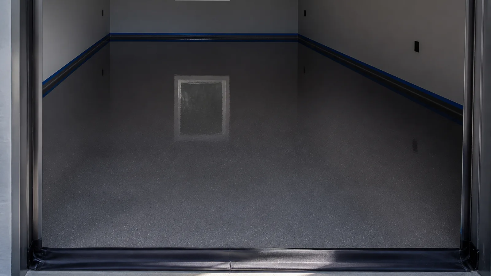 Freshly coated epoxy garage floor taped off while the coating cures